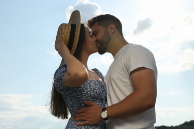 Romantic date. Beautiful couple kissing against blue sky