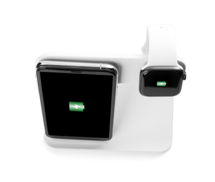 Photo of Mobile phone and smartwatch charging with wireless pad on white background, above view
