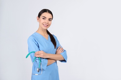 Photo of Portrait of medical assistant with stethoscope on light background. Space for text