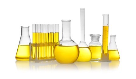 Photo of Laboratory glassware with yellow liquid on white background