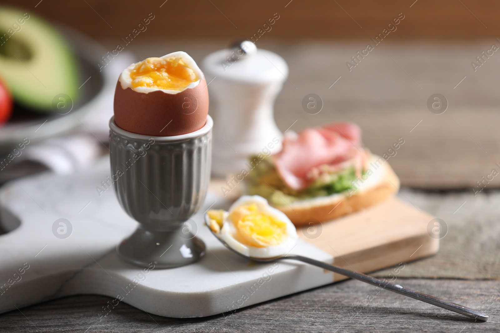 Photo of Soft boiled chicken egg served on wooden table, space for text