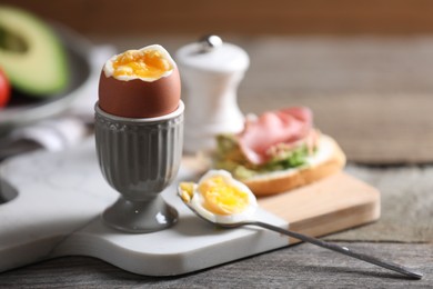 Photo of Soft boiled chicken egg served on wooden table, space for text