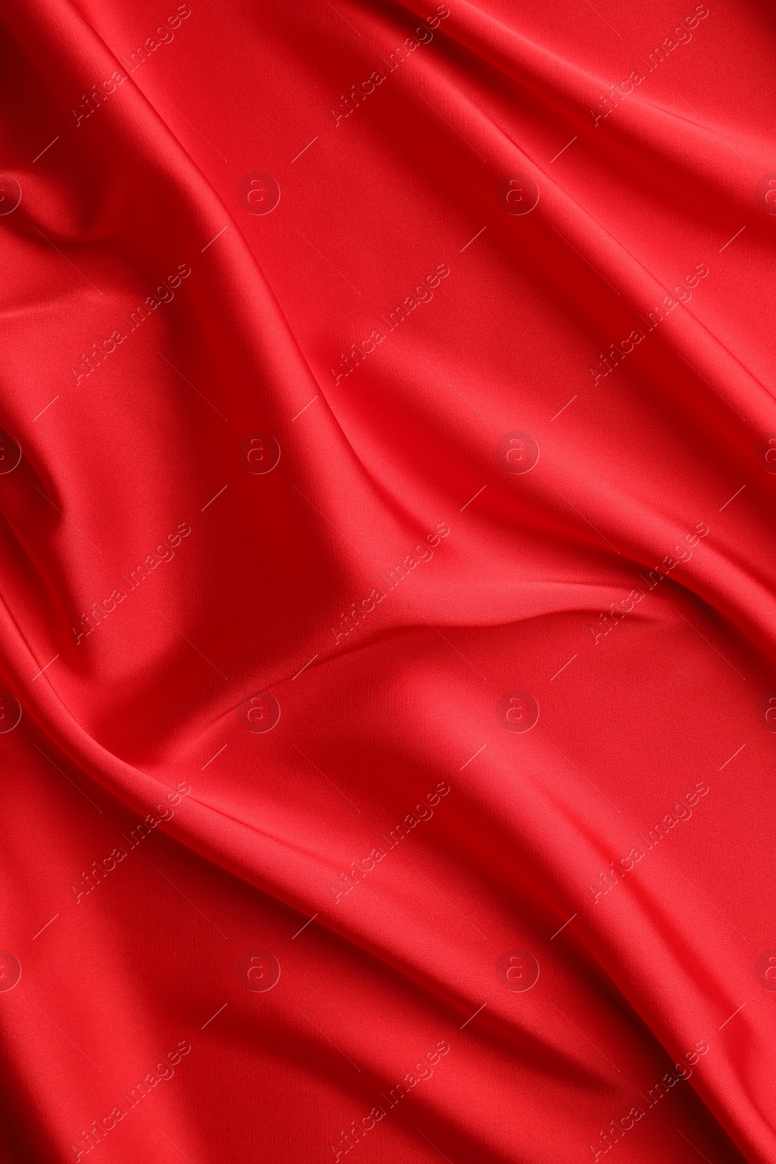 Photo of Crumpled red silk fabric as background, top view