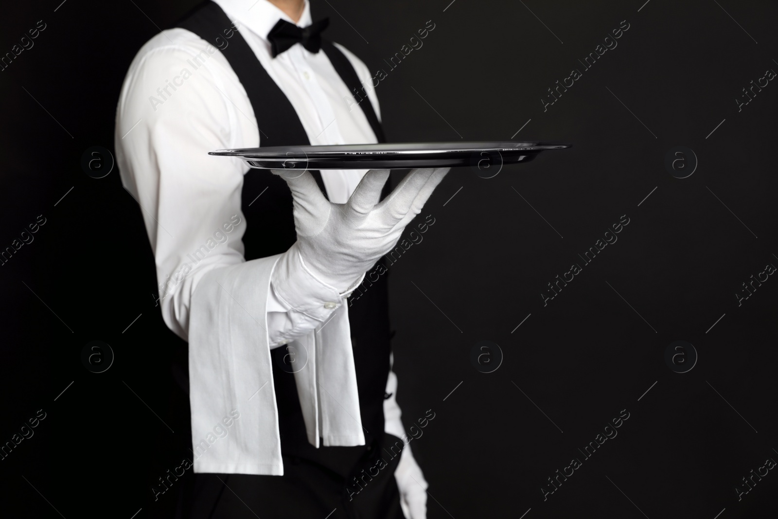 Photo of Butler with tray on black background, closeup