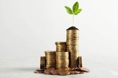 Photo of Stacked coins and green sprout on white background. Investment concept