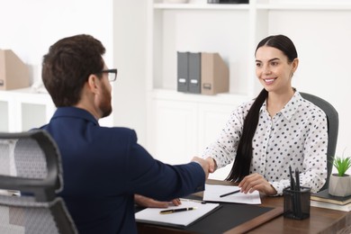 Photo of Lawyer shaking hands with client in office, selective focus