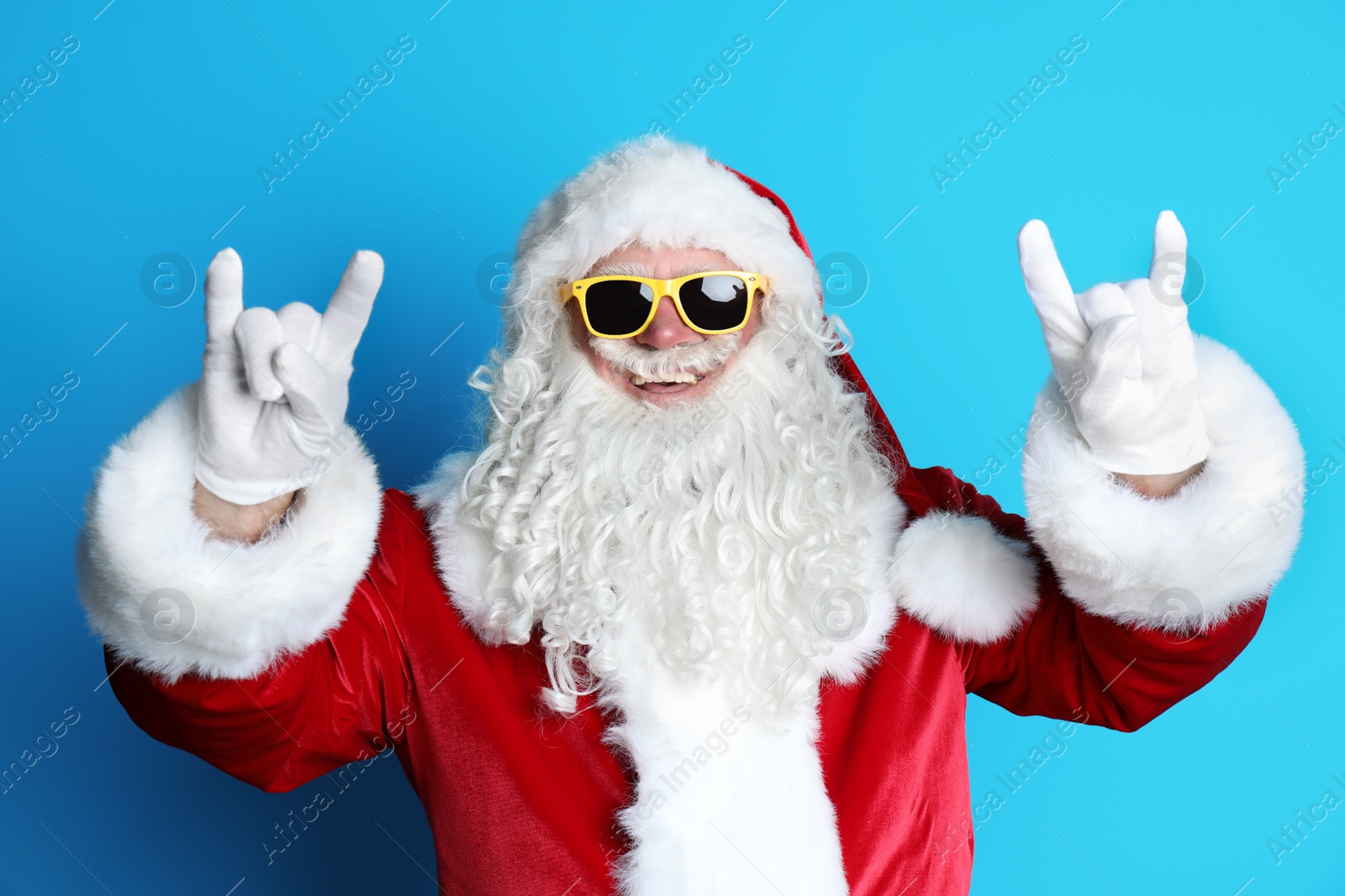 Photo of Authentic Santa Claus wearing sunglasses on color background