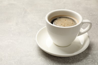 Photo of Cup of aromatic coffee on light grey table, closeup. Space for text