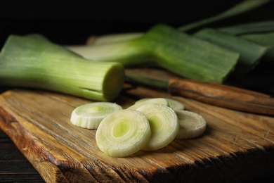 Photo of Fresh raw leek on cutting board, closeup. Ripe onion
