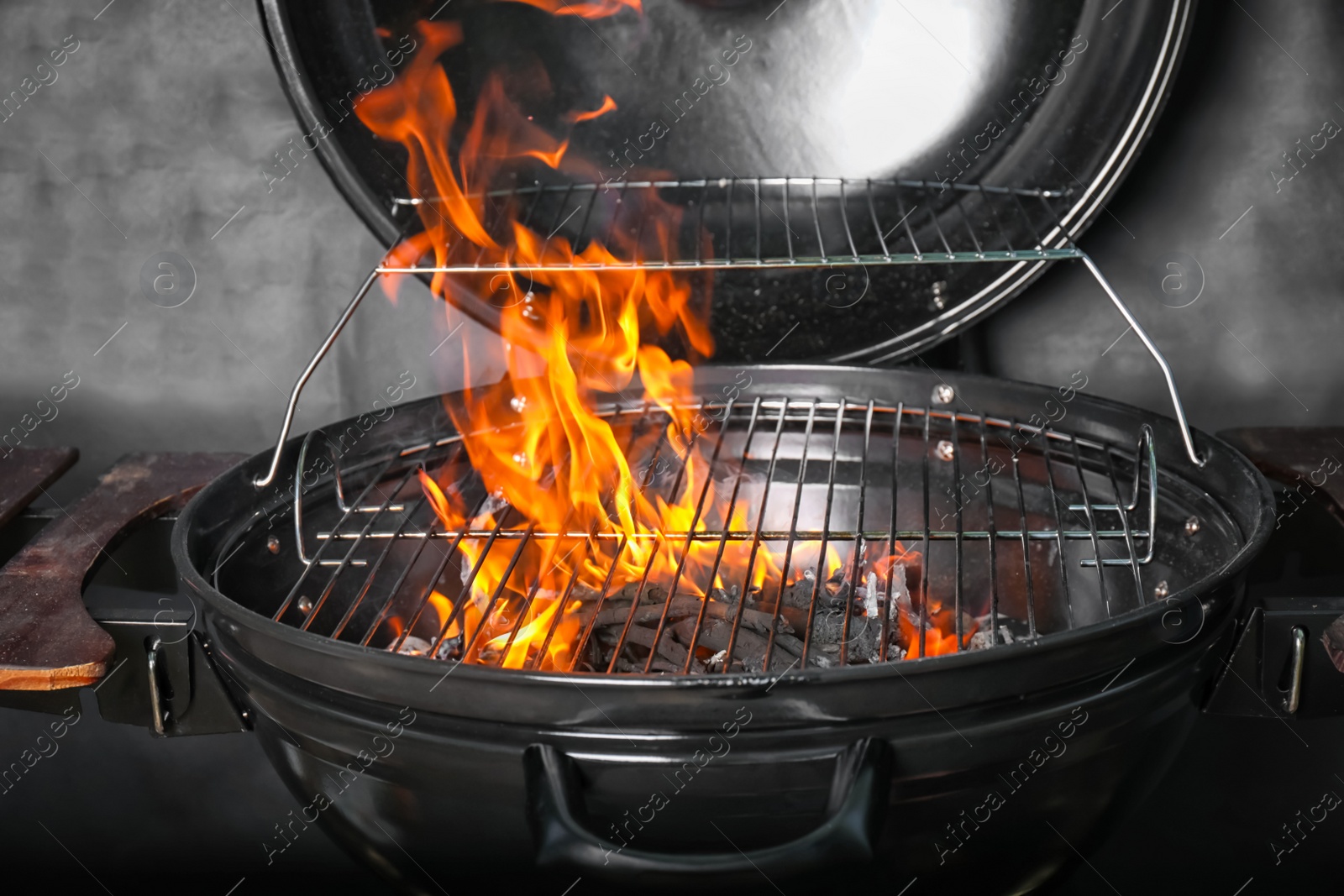 Photo of New modern barbecue grill with coals on black background