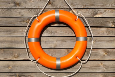 Orange life buoy hanging on wooden wall