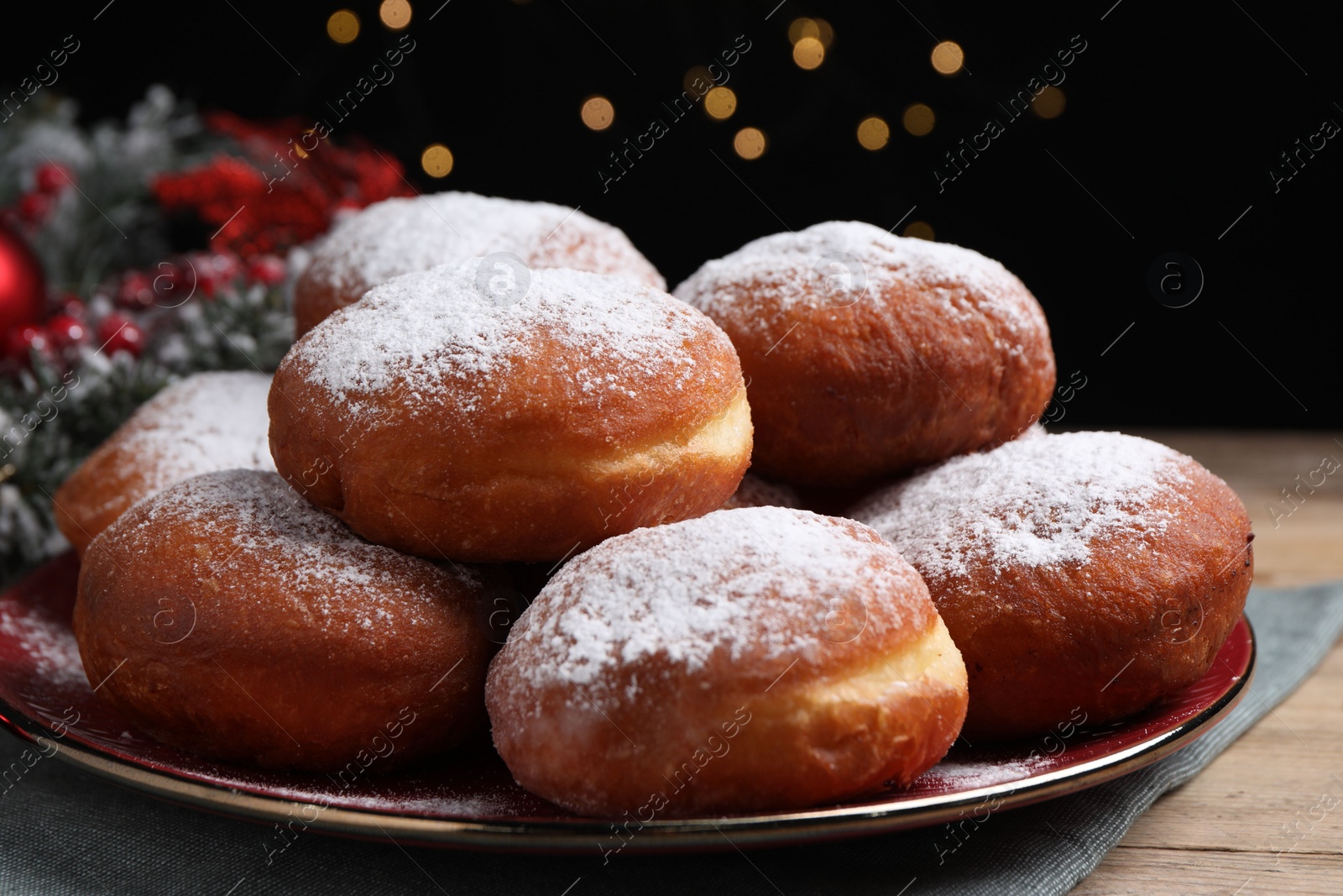 Photo of Delicious sweet buns on table against black background with blurred lights, closeup