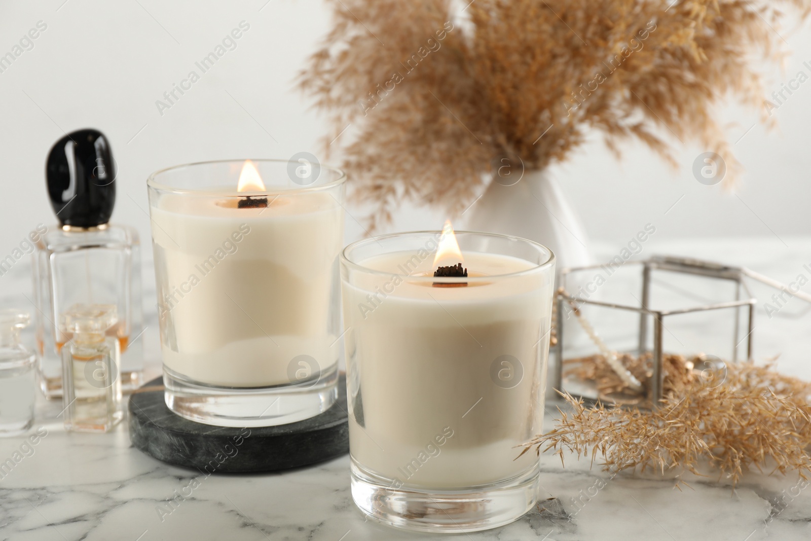 Photo of Composition with burning soy candles on white marble table