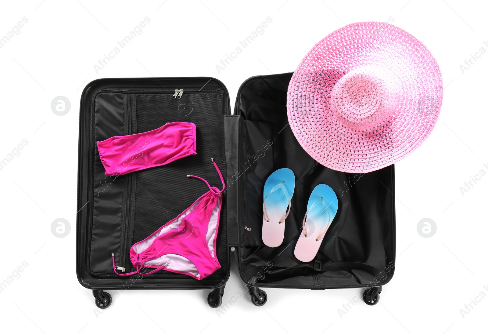 Photo of Suitcase with bikini, hat and slippers on white background, top view