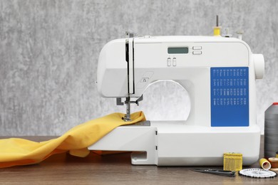 Sewing machine with fabric and craft accessories on wooden table