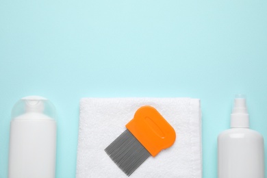 Photo of Products for anti lice treatment, metal comb and towel on light blue background, flat lay. Space for text