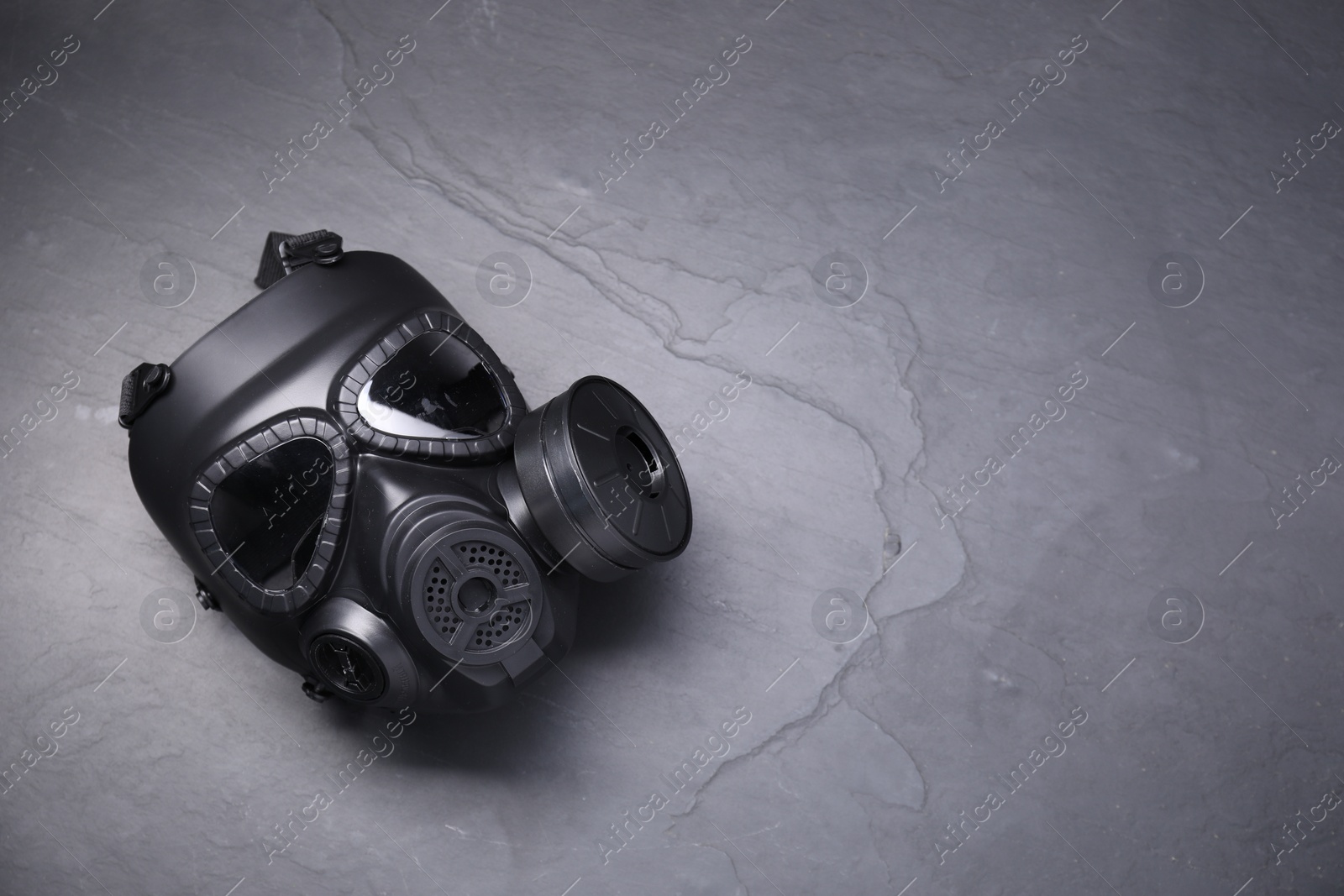 Photo of One gas mask on grey textured background, top view. Space for text