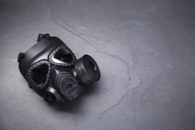 One gas mask on grey textured background, top view. Space for text