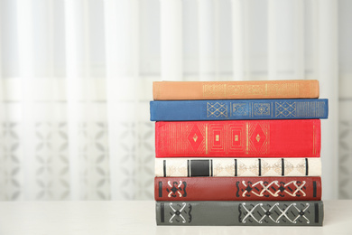 Collection of different books on table indoors. Space for text