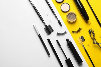 Photo of Flat lay composition with false eyelashes and other makeup products on color background, space for text