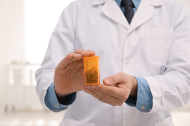 Photo of Professional pharmacist with pills in drugstore, closeup