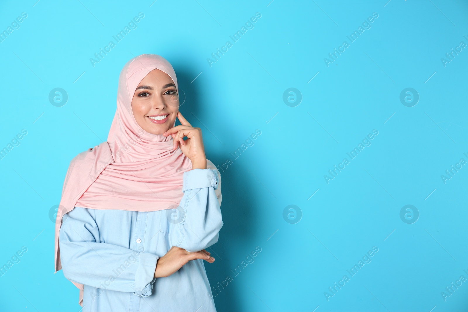 Photo of Portrait of young Muslim woman in hijab against color background. Space for text