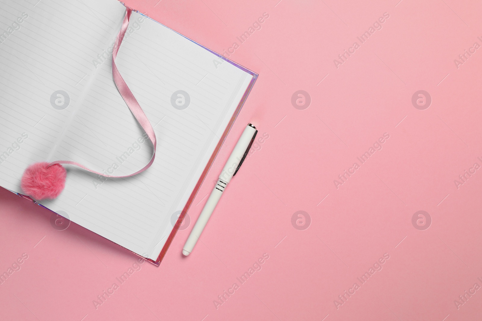Photo of Top view of open planner with pen on colorful background. Space for text