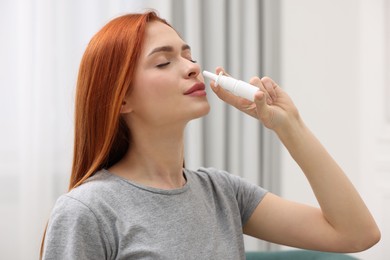 Medical drops. Woman using nasal spray at home