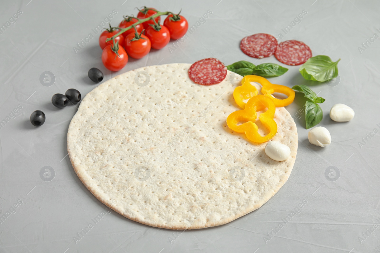 Photo of Base and ingredients for pizza on light table