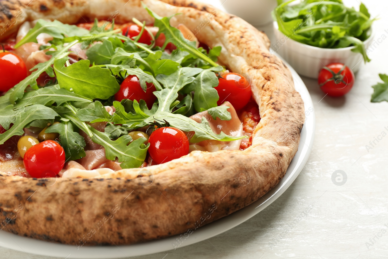 Photo of Tasty pizza with meat and arugula on white table, closeup