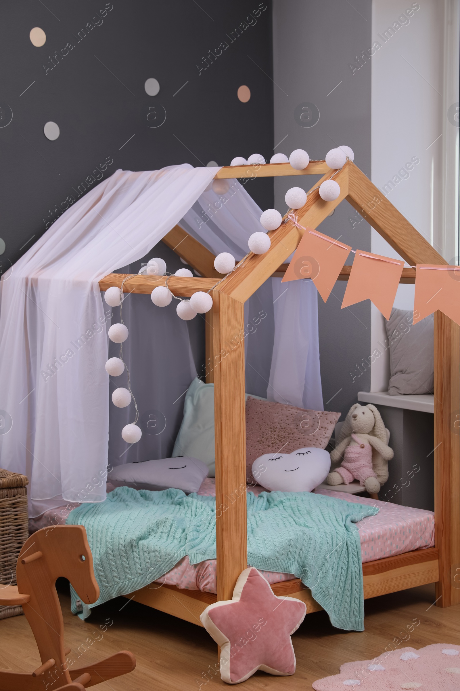 Photo of Stylish child room interior with house bed and different toys