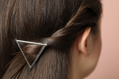 Young woman with beautiful hair clip on pink background, closeup