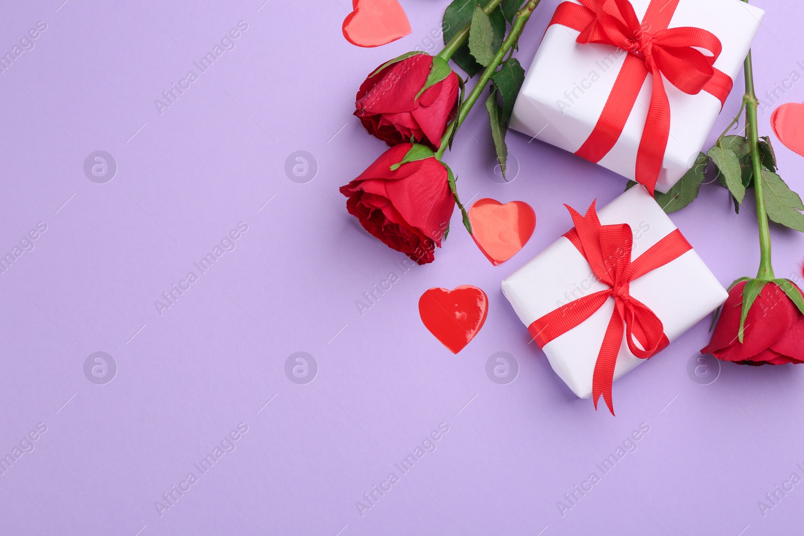 Photo of Gift boxes, roses and hearts on violet background, flat lay with space for text. Valentine's Day celebration