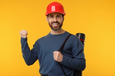 Architect in hard hat with drawing tube on orange background