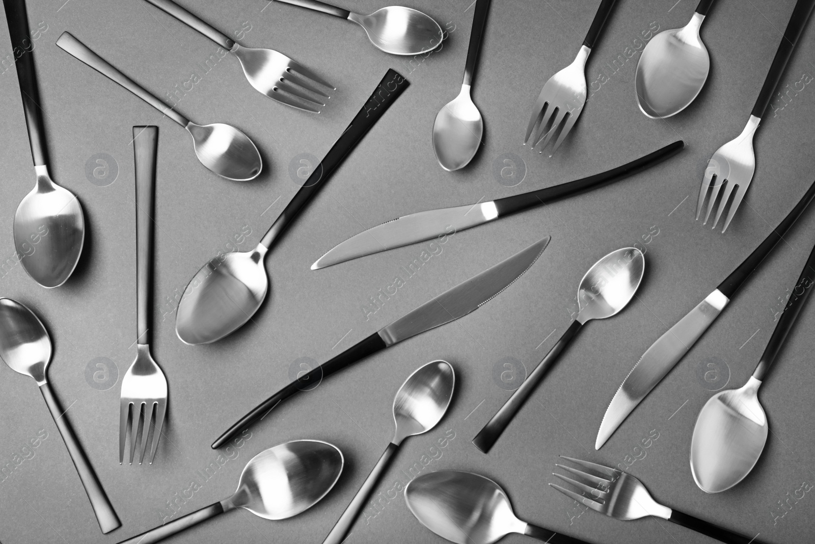 Photo of Set of new metal cutlery on black background, flat lay