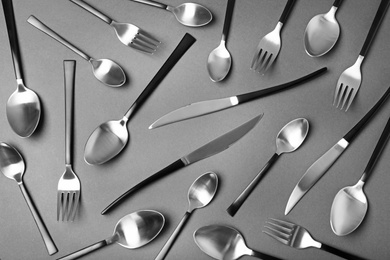 Photo of Set of new metal cutlery on black background, flat lay