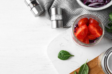 Healthy salad in glass jar on white wooden table, flat lay. Space for text