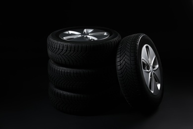 Photo of Set of wheels with winter tires on black background