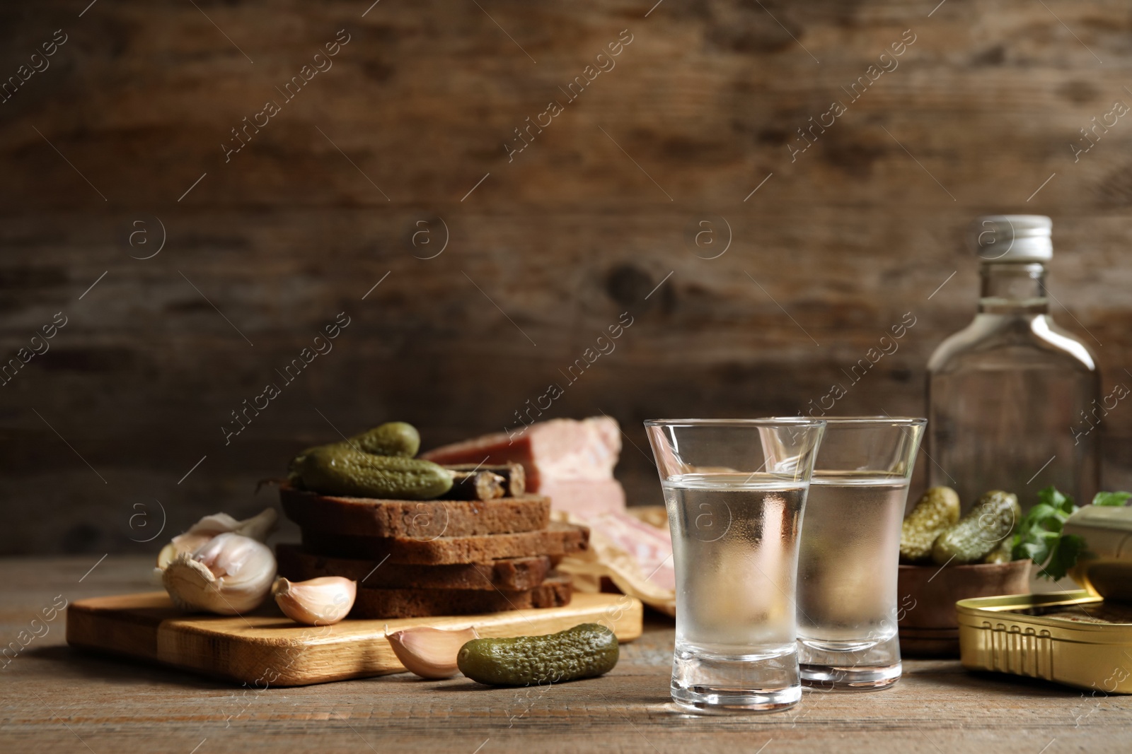 Photo of Cold Russian vodka with snacks on wooden table