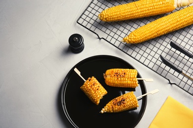 Photo of Flat lay composition with tasty corn cobs on light background