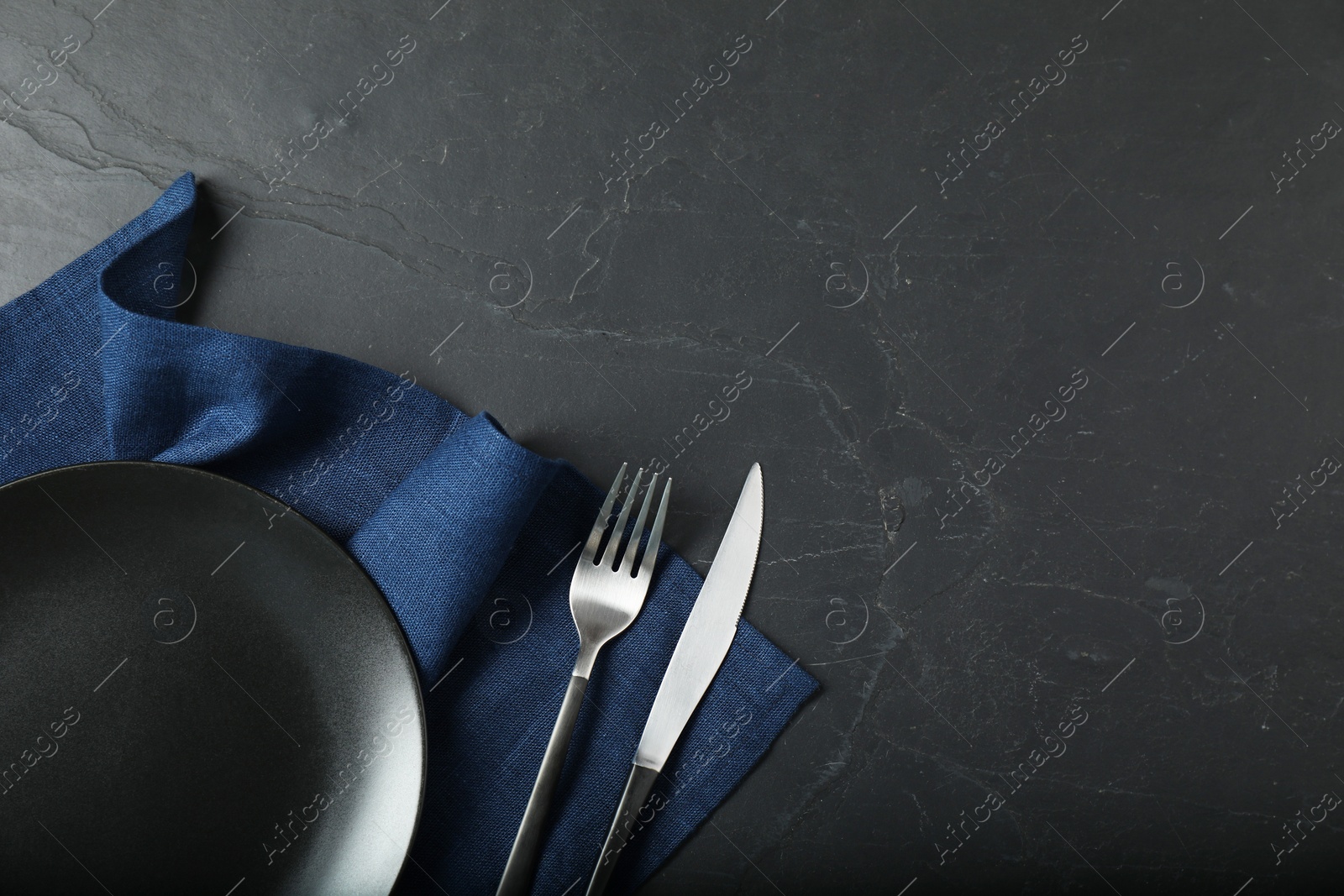 Photo of Stylish setting with elegant cutlery on grey textured table, flat lay. Space for text