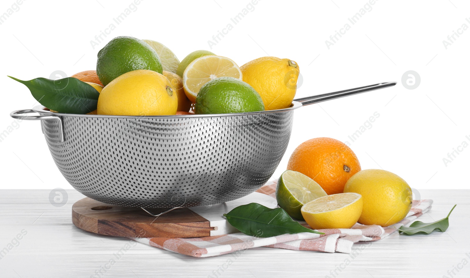 Photo of Metal colander with citrus fruits on table against white background