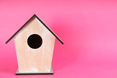 Beautiful bird house on pink background, space for text