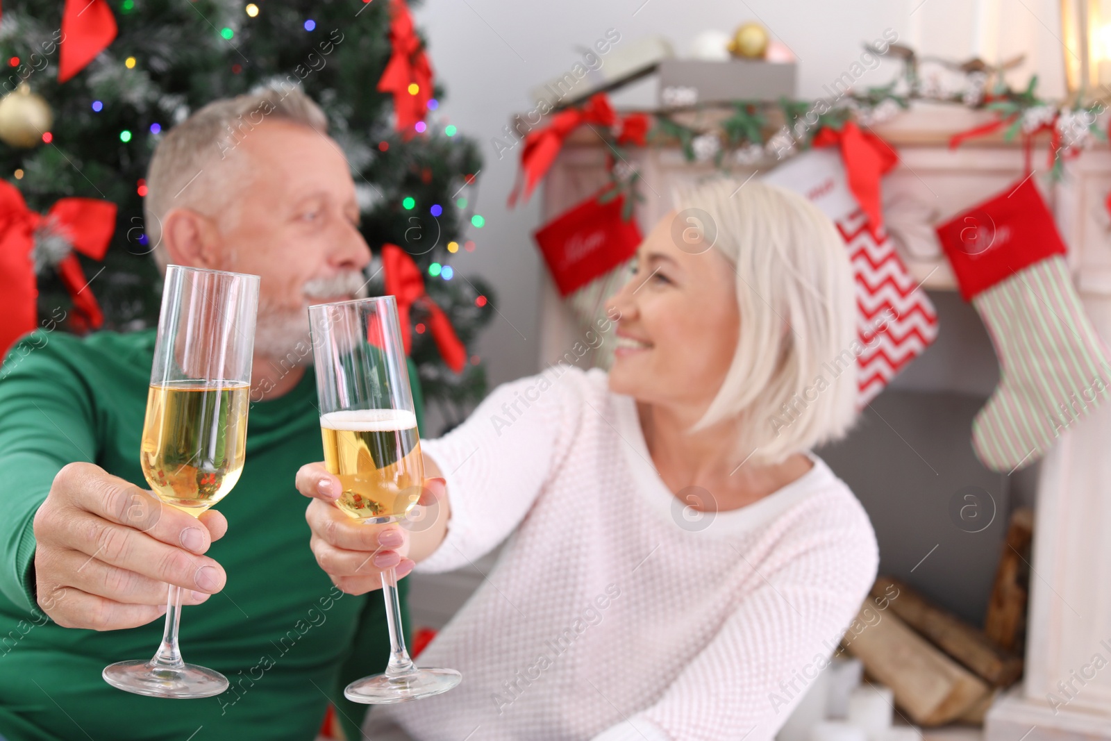 Photo of Mature couple with glasses of champagne at home. Christmas celebration