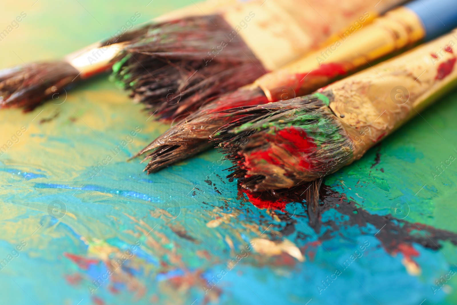 Photo of Abstract colorful artwork and brushes, closeup view