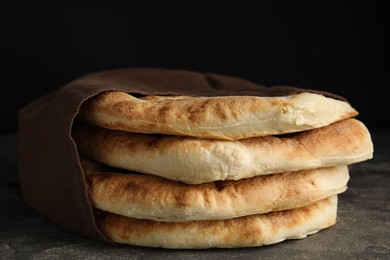 Photo of Delicious fresh pita bread and napkin on grey table, closeup