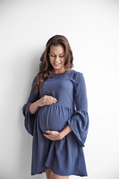 Happy young pregnant woman on white background