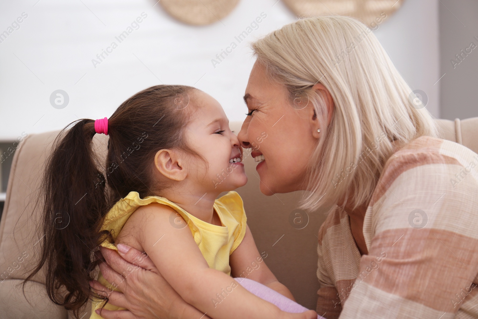 Photo of Happy granddaughter and grandmother together at home