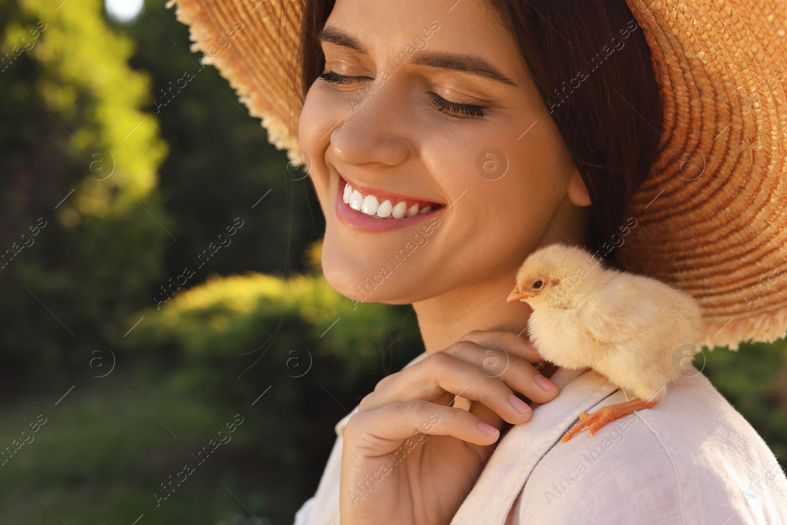 Photo of Beautiful woman with cute chick outdoors. Baby animal