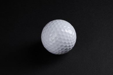 Photo of One golf ball on black background, closeup